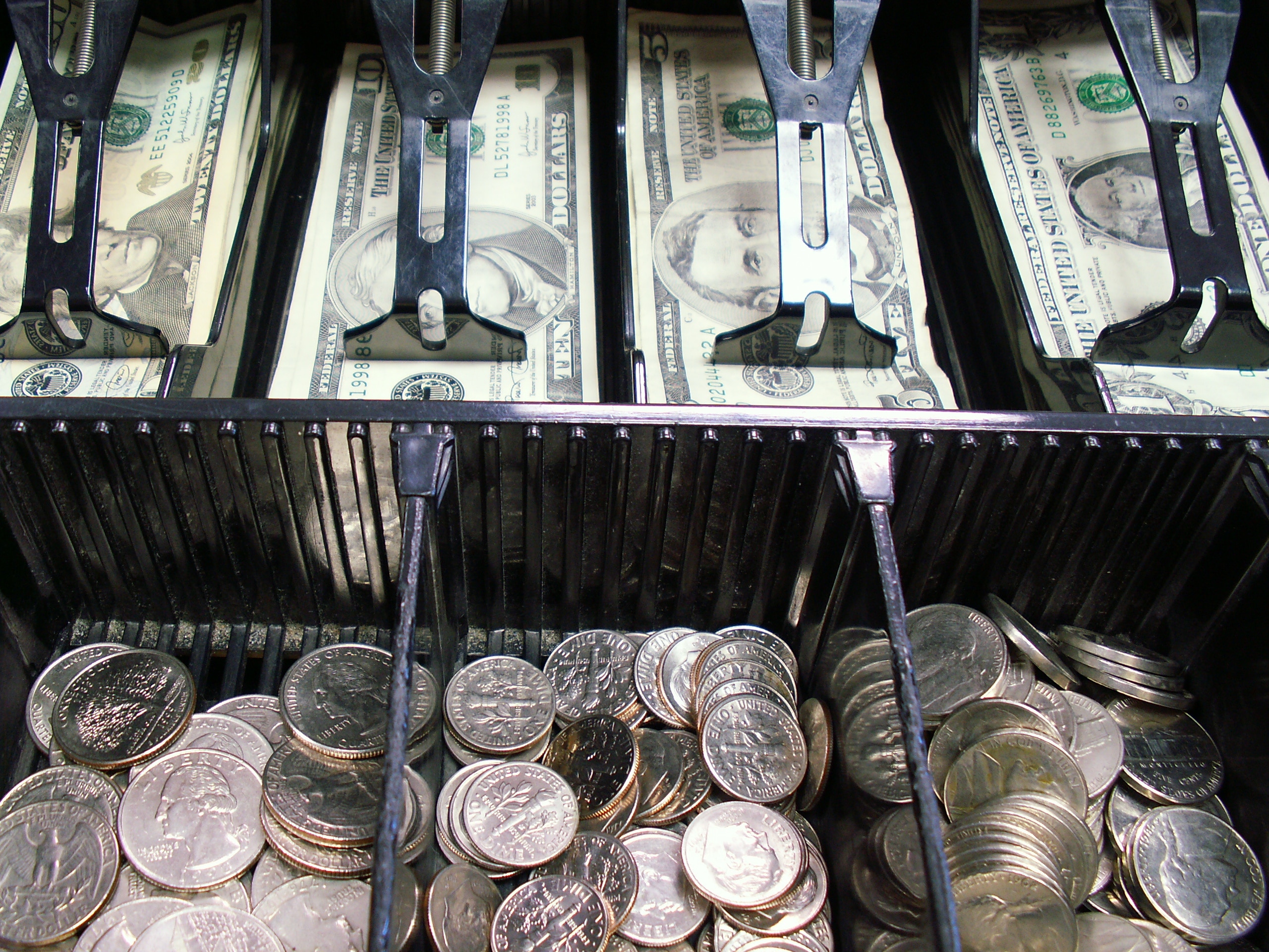cash register bills and coins in a cash register